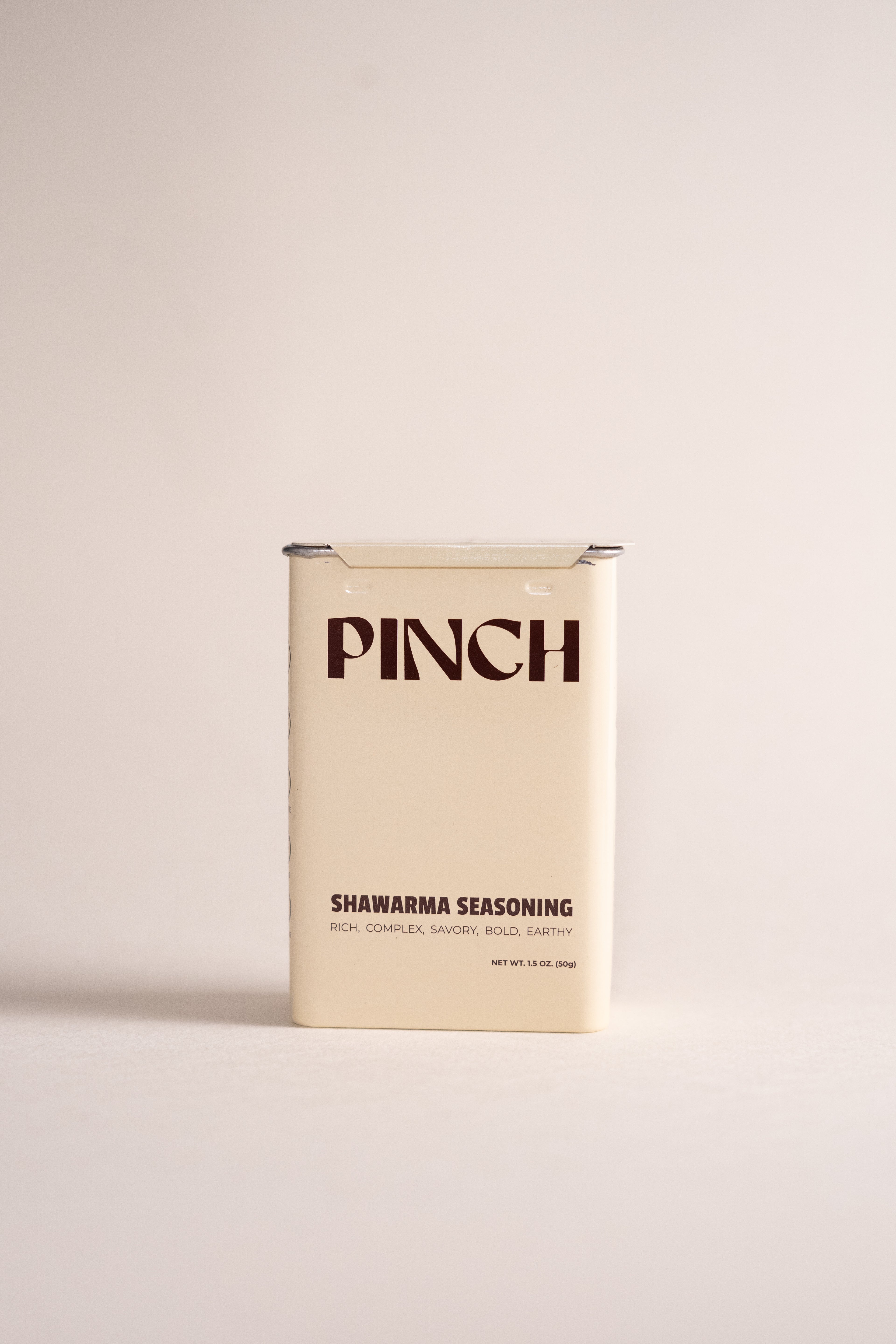 Light yellow PINCH Shawarma Seasoning packaging on a beige background