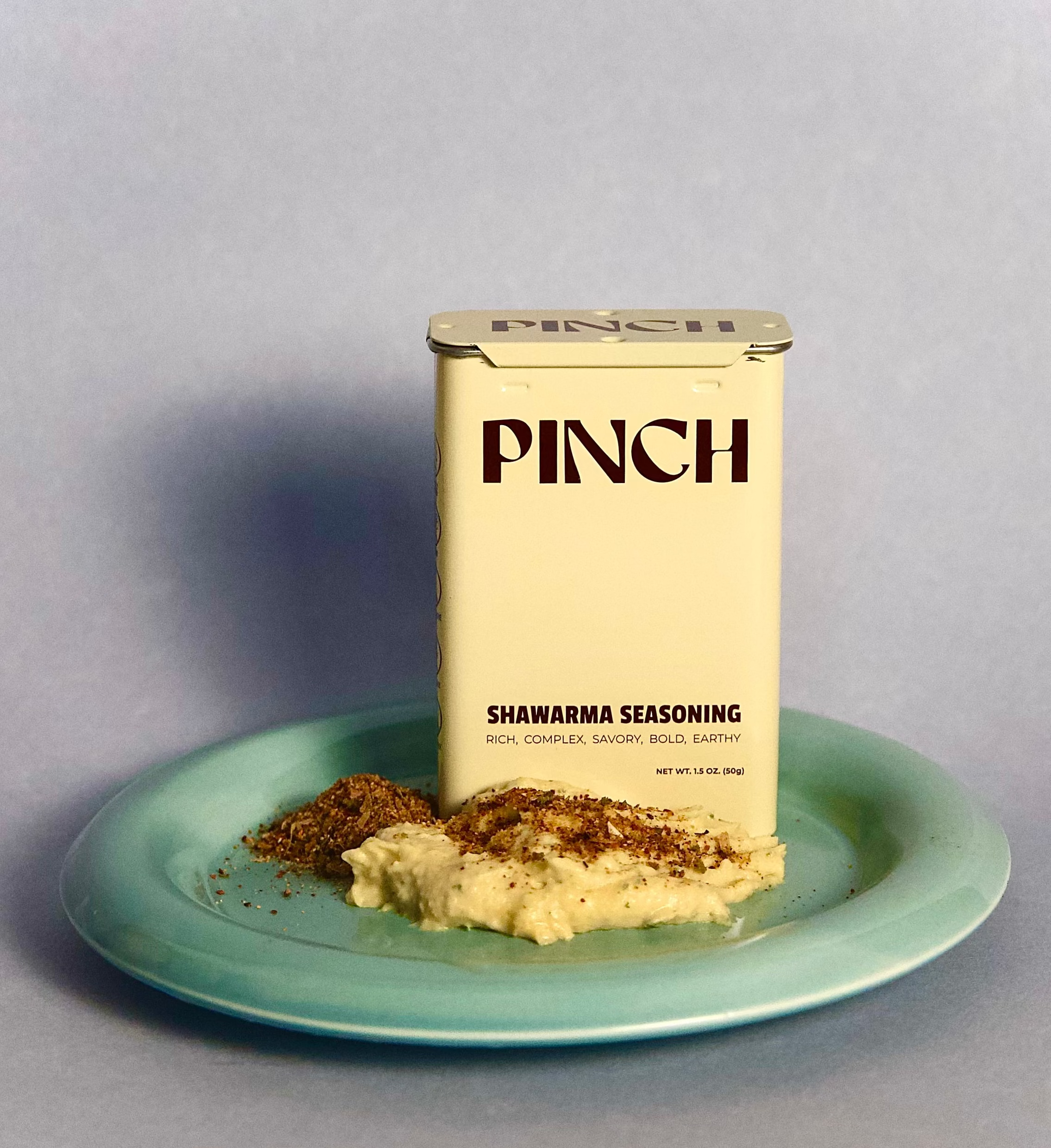 PINCH shawarma seasoning can on a blue plate with hummus and seasoning